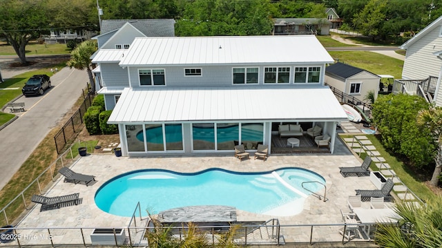 1205 Kings Lndg, Hampstead, NC 28443 - rear view of property featuring metal roof, a fenced backyard, a patio, and a pool with connected hot tub