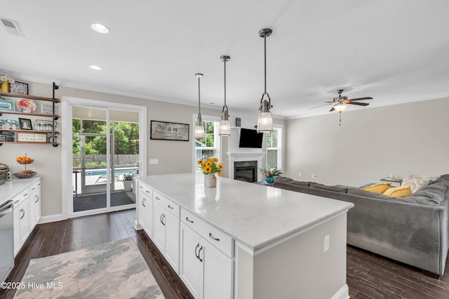 7869 Champlain Dr, Wilmington, NC 28412 - kitchen with dark wood-style floors, ceiling fan, healthy amount of natural light, white cabinetry, and ornamental molding