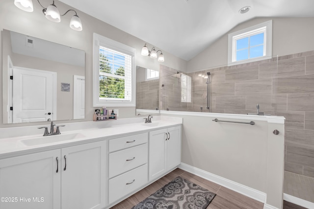 7869 Champlain Dr, Wilmington, NC 28412 - bathroom featuring vaulted ceiling, double vanity, walk in shower, and wood finished floors