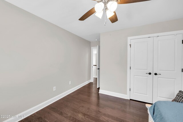 7869 Champlain Dr, Wilmington, NC 28412 - bedroom with baseboards, dark wood-style flooring, a closet, and a ceiling fan
