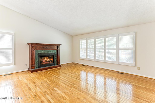 129 Shagbark Ct, Seven Lakes, NC 27376 - unfurnished living room with wood-type flooring, lofted ceiling, healthy amount of natural light, and a premium fireplace