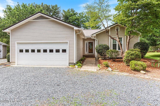 129 Shagbark Ct, West End, NC 27376 - ranch-style home featuring gravel driveway, metal roof, and an attached garage