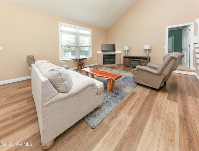 106 Sound Shore Dr, Currituck, NC 27929 - living area featuring a brick fireplace, wood finished floors, high vaulted ceiling, and baseboards