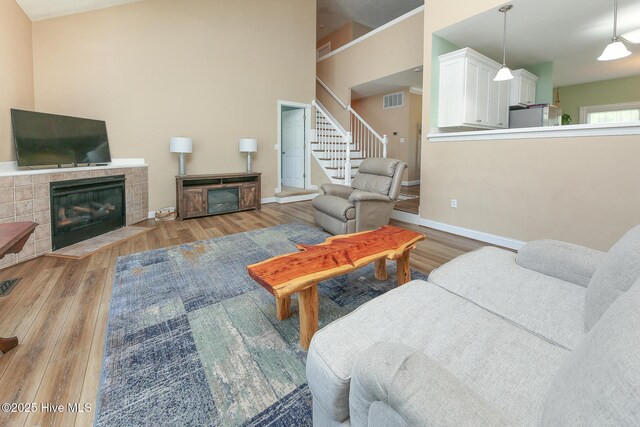 106 Sound Shore Dr, Currituck, NC 27929 - living room with a tiled fireplace, wood finished floors, stairway, and baseboards