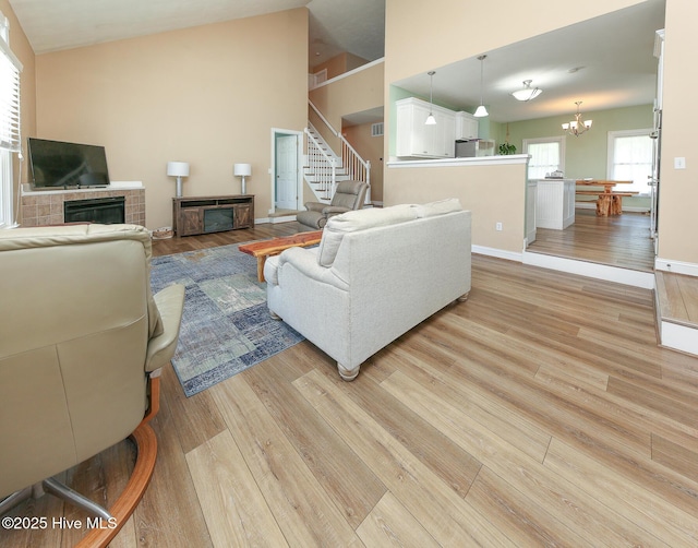 106 Sound Shore Dr, Currituck, NC 27929 - living area with a glass covered fireplace, light wood finished floors, a chandelier, stairway, and lofted ceiling