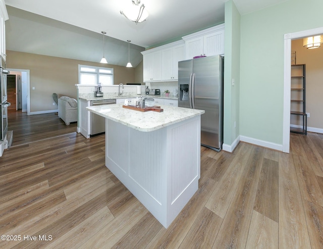 106 Sound Shore Dr, Currituck, NC 27929 - kitchen with appliances with stainless steel finishes, a peninsula, a sink, white cabinetry, and light stone counters