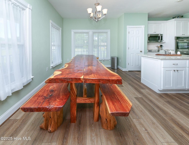 106 Sound Shore Dr, Currituck, NC 27929 - dining space featuring wood finished floors, a chandelier, and baseboards