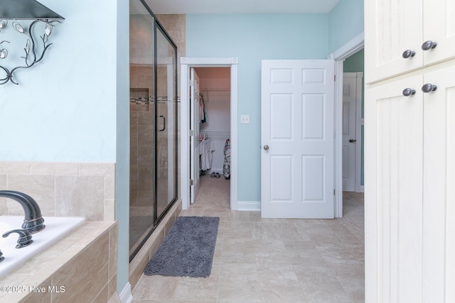 106 Sound Shore Dr, Currituck, NC 27929 - bathroom with a stall shower, a garden tub, a walk in closet, and baseboards