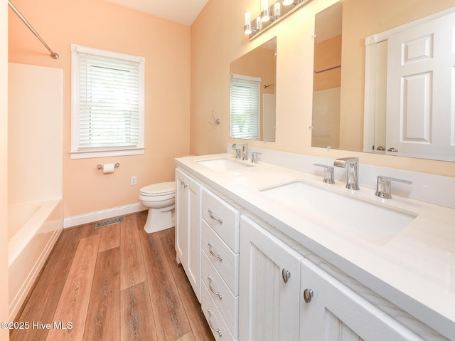 106 Sound Shore Dr, Currituck, NC 27929 - full bath featuring toilet, baseboards, wood finished floors, double vanity, and shower / washtub combination
