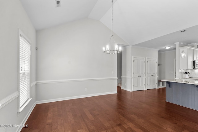 3068 Joe Stocks Rd, Greenville, NC 27858 - kitchen with vaulted ceiling, a kitchen breakfast bar, white cabinetry, a chandelier, and pendant lighting