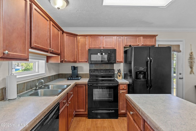 233 NE 70th St, Oak Island, NC 28465 - kitchen featuring black appliances, a sink, light wood-style flooring, light countertops, and ornamental molding
