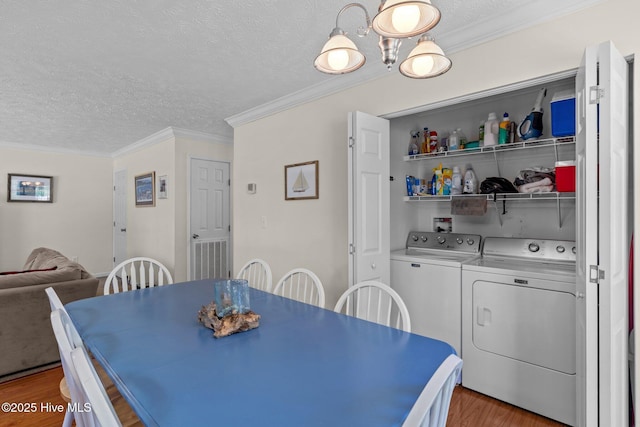 233 NE 70th St, Oak Island, NC 28465 - dining room featuring washing machine and dryer, a textured ceiling, wood finished floors, and ornamental molding