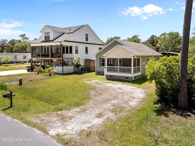 233 NE 70th St, Oak Island, NC 28465 - view of front of home with a sunroom, crawl space, driveway, and a front lawn