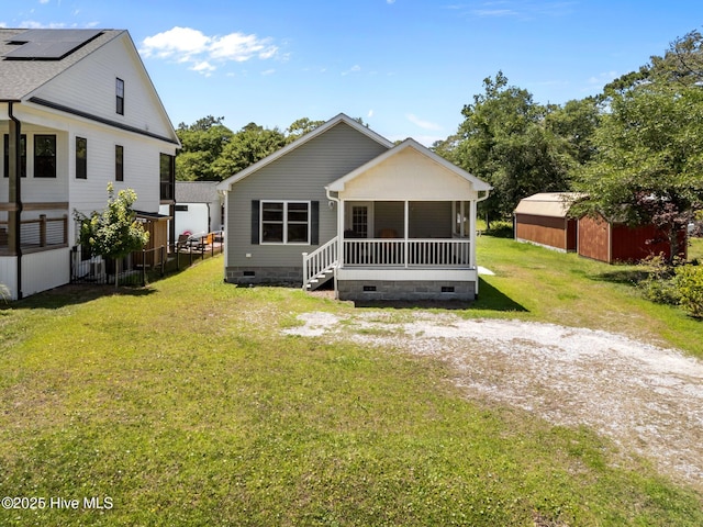 233 NE 70th St, Oak Island, NC 28465 - back of property featuring crawl space, a sunroom, a lawn, and an outdoor structure