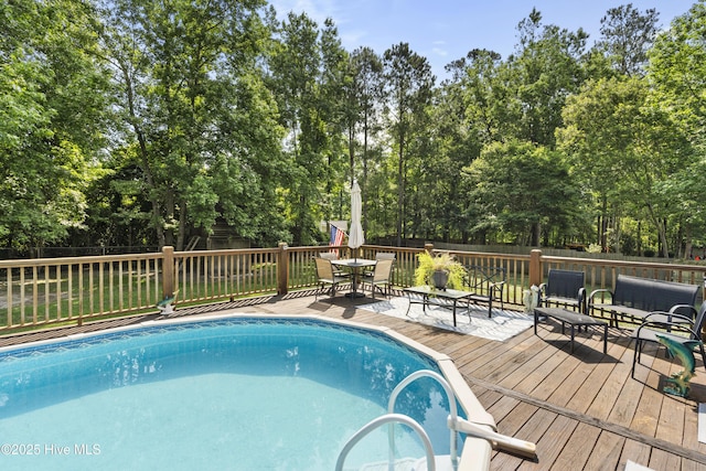 130 Combine Ln, Leland, NC 28451 - view of swimming pool with a deck, outdoor dining space, a fenced backyard, and view of wooded area