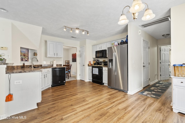 130 Combine Ln, Leland, NC 28451 - kitchen with black appliances, light wood finished floors, a sink, and white cabinets