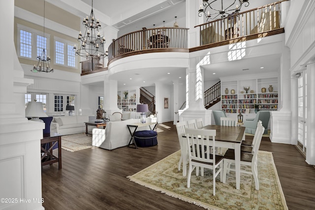 557 Moss Lake Ln, Holly Ridge, NC 28445 - dining area with a chandelier, a towering ceiling, wood finished floors, and decorative columns