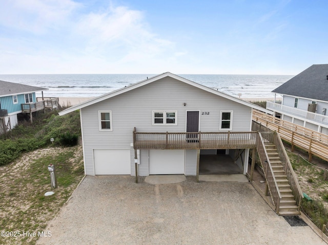 232 Seashore Dr, North Topsail Beach, NC 28460 - rear view of house with a garage, stairs, driveway, and a deck with water view