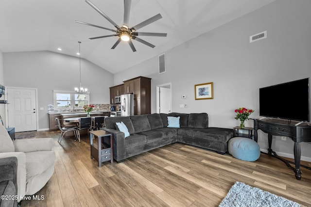 232 Seashore Dr, North Topsail Beach, NC 28460 - living room with high vaulted ceiling, a chandelier, ceiling fan, and light wood-style flooring