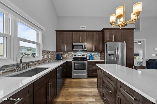 232 Seashore Dr, North Topsail Beach, NC 28460 - kitchen featuring stainless steel appliances, a sink, backsplash, light countertops, and dark brown cabinetry