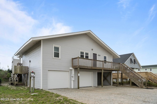 232 Seashore Dr, North Topsail Beach, NC 28460 - back of house featuring stairway, an attached garage, driveway, and a wooden deck