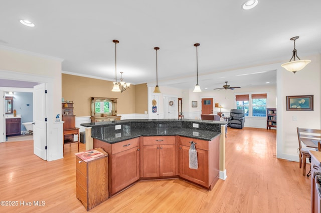 2013 Adams St, Wilmington, NC 28401 - kitchen featuring open floor plan, light wood-type flooring, decorative light fixtures, dark stone countertops, and ornamental molding