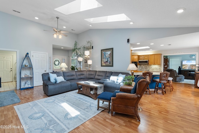 4 Golf Crest Ct, Carolina Shores, NC 28467 - living room with a skylight, high vaulted ceiling, light wood finished floors, recessed lighting, and a ceiling fan