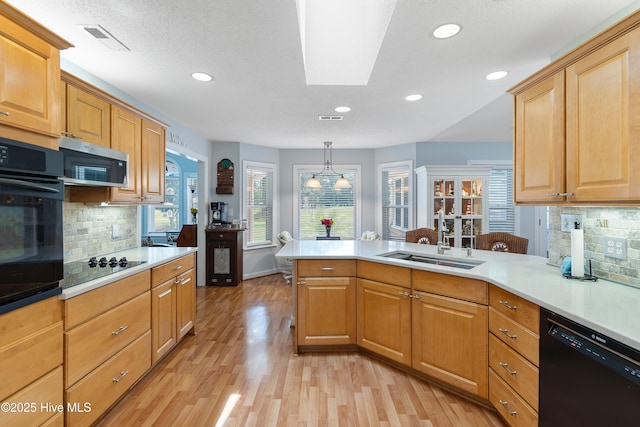 4 Golf Crest Ct, Carolina Shores, NC 28467 - kitchen featuring black appliances, a sink, a peninsula, light countertops, and light wood-style floors