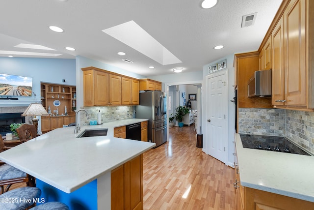 4 Golf Crest Ct, Carolina Shores, NC 28467 - kitchen featuring a sink, black appliances, a peninsula, a skylight, and a breakfast bar area