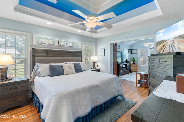 4 Golf Crest Ct, Carolina Shores, NC 28467 - bedroom featuring a tray ceiling, light wood-style floors, ornamental molding, recessed lighting, and a ceiling fan