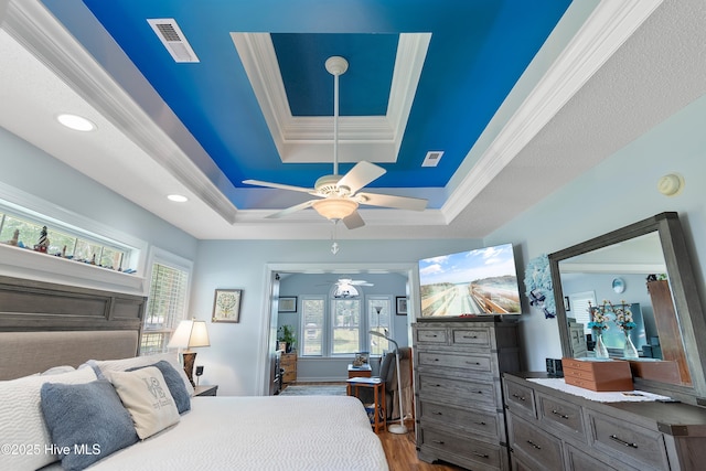 4 Golf Crest Ct, Carolina Shores, NC 28467 - bedroom featuring a raised ceiling, multiple windows, wood finished floors, ornamental molding, and a ceiling fan