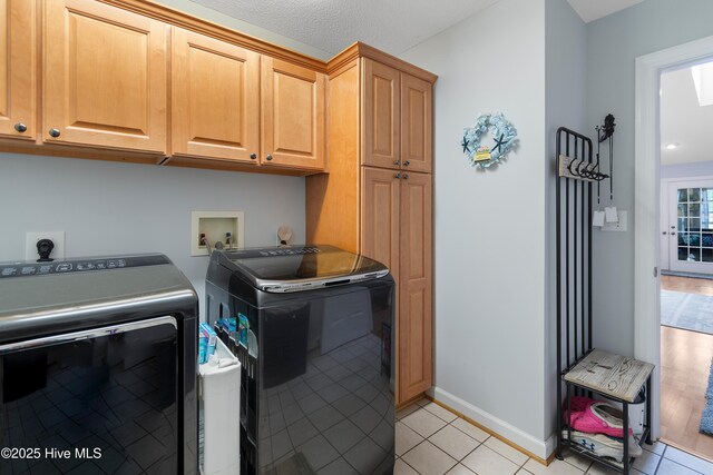 4 Golf Crest Ct, Carolina Shores, NC 28467 - laundry area featuring cabinet space, separate washer and dryer, light tile patterned flooring, and baseboards