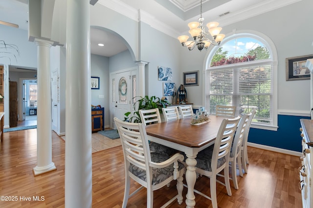 4 Golf Crest Ct, Carolina Shores, NC 28467 - dining space featuring ornate columns, arched walkways, plenty of natural light, light wood-style flooring, and crown molding