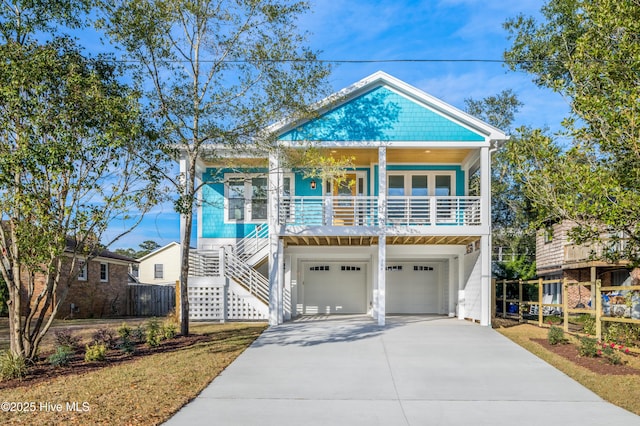 110 Dow Rd N, Carolina Beach, NC 28428 - coastal inspired home featuring stairs, a porch, driveway, and a garage