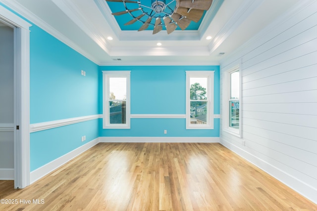 110 Dow Rd N, Carolina Beach, NC 28428 - empty room featuring plenty of natural light, wood finished floors, a tray ceiling, ornamental molding, and baseboards