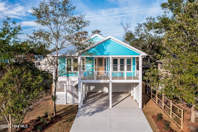 110 Dow Rd N, Carolina Beach, NC 28428 - coastal inspired home with a carport, stairway, and driveway