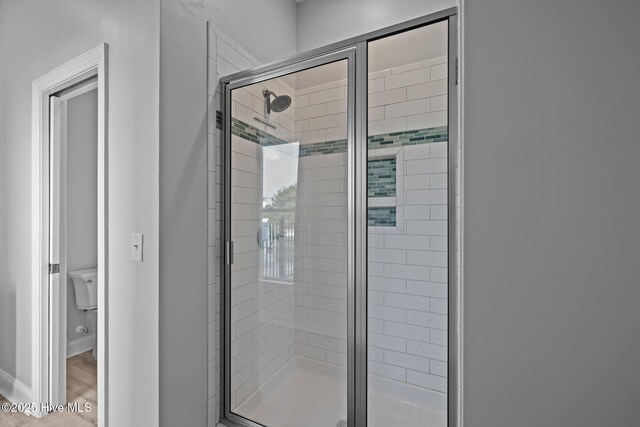 1905 Emerald Dr, Emerald Isle, NC 28594 - full bathroom with a shower stall, baseboards, toilet, and wood finished floors