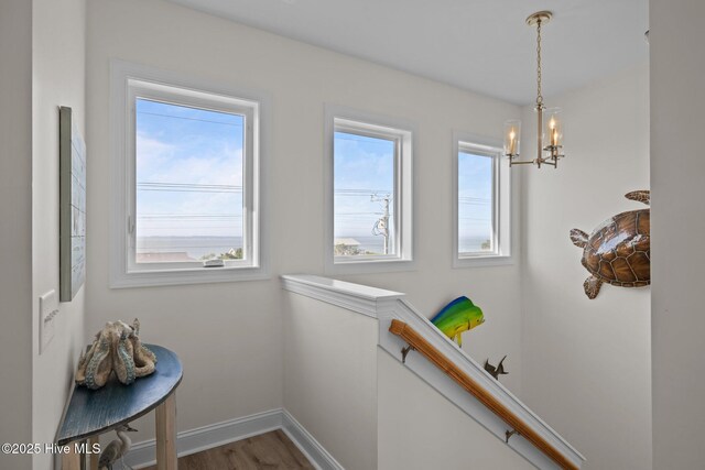 1905 Emerald Dr, Emerald Isle, NC 28594 - hallway featuring an upstairs landing, a chandelier, wood finished floors, and baseboards