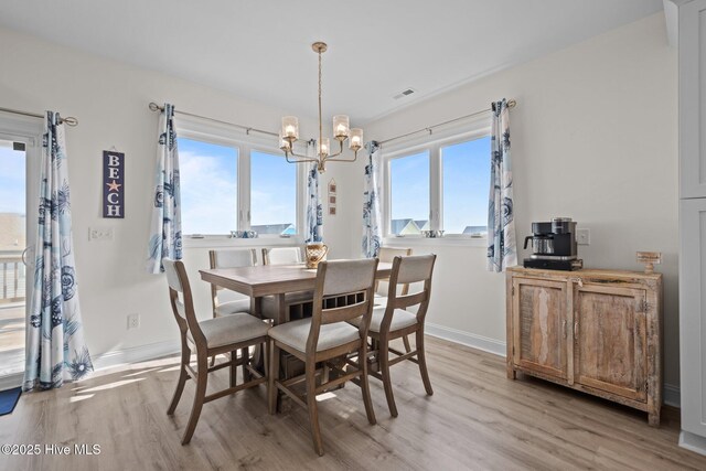 1905 Emerald Dr, Emerald Isle, NC 28594 - dining room with light wood-style floors, a chandelier, and baseboards