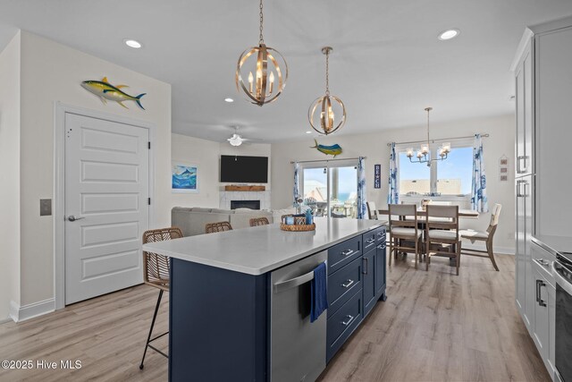 1905 Emerald Dr, Emerald Isle, NC 28594 - kitchen featuring a chandelier, a fireplace, a kitchen bar, light wood-style floors, and blue cabinets