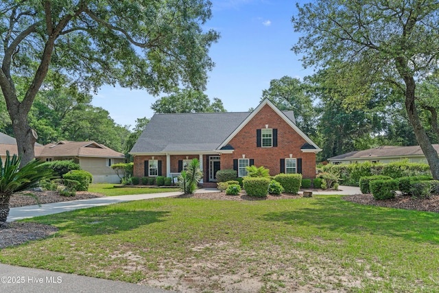 550 Sunset Lakes Blvd SW, Sunset Beach, NC 28468 - view of front facade featuring brick siding, a front lawn, a porch, and roof with shingles