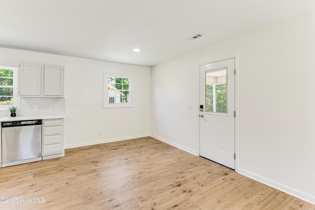 150 Willetts Dr, Southport, NC 28461 - kitchen featuring dishwasher, light wood-style floors, decorative backsplash, light countertops, and baseboards