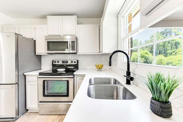 150 Willetts Dr, Southport, NC 28461 - kitchen with stainless steel appliances, a sink, light countertops, and white cabinets