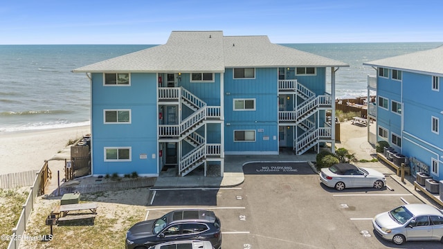 1437 Fort Fisher Blvd S Unit D3, Kure Beach, NC 28449 - view of building exterior featuring uncovered parking, view of water and beach, stairway, and central air condition unit