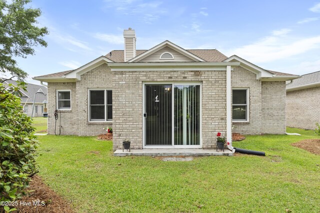 106 N Shore Dr, Sneads Ferry, NC 28460 - back of property featuring a yard, brick siding, a chimney, and a shingled roof