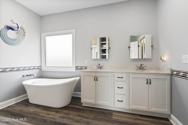 106 N Shore Dr, Sneads Ferry, NC 28460 - bathroom with double vanity, a soaking tub, wood finished floors, and baseboards