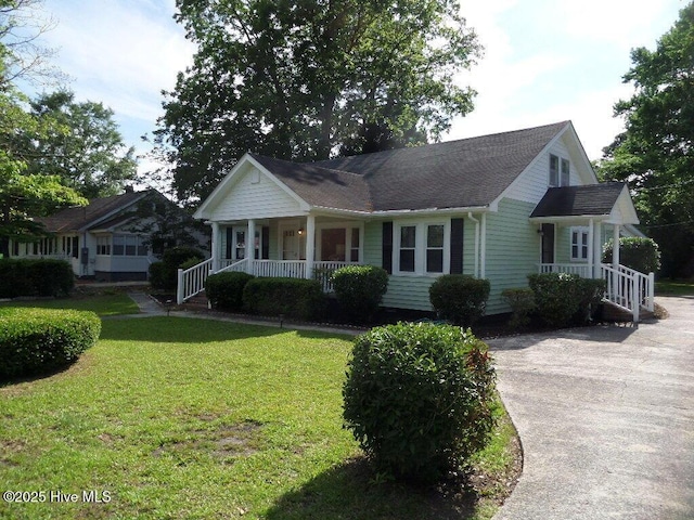 108 Swan Point Rd, Bayboro, NC 28515 - view of front of property with covered porch, a front lawn, a shingled roof, and driveway