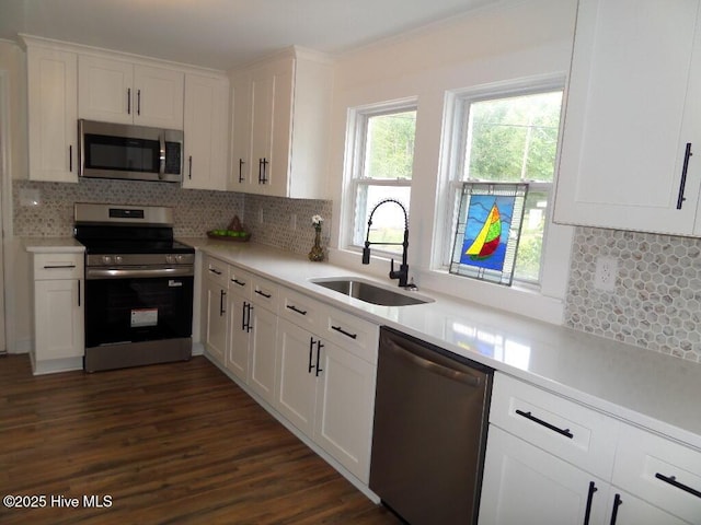 108 Swan Point Rd, Bayboro, NC 28515 - kitchen with stainless steel appliances, a sink, white cabinetry, and backsplash