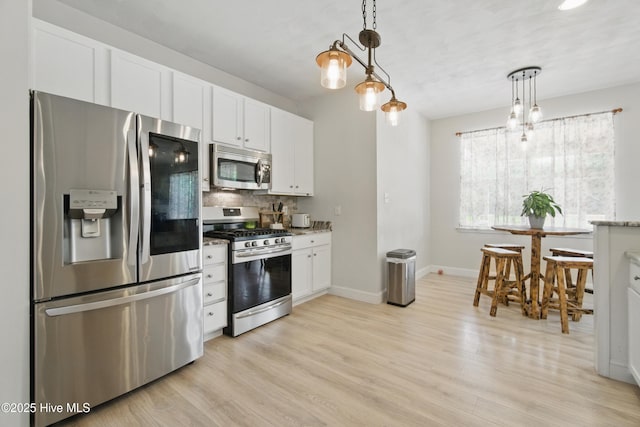118 Stedman Ln E, Elizabeth City, NC 27909 - kitchen with stainless steel appliances, decorative backsplash, light wood finished floors, and white cabinets