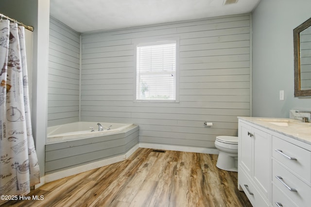 118 Stedman Ln E, Elizabeth City, NC 27909 - full bathroom featuring wood finished floors, vanity, a garden tub, toilet, and wood walls